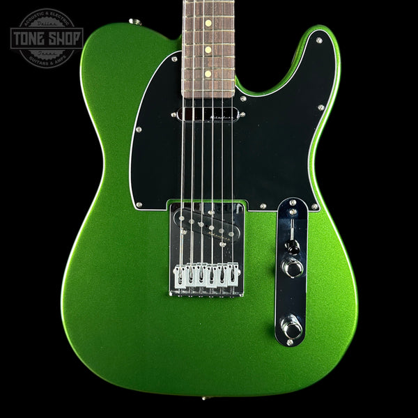 A green metallic electric guitar with a black pickguard and chrome hardware, shown against a solid black background with a Tone Shop watermark in the top left corner.