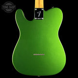 The back of a Fender Telecaster electric guitar in a vibrant metallic lime green finish, featuring a black plate with the silver Fender logo and a light wood neck visible at the top, set against a solid black background.