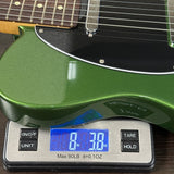 A green electric guitar body resting on a digital scale showing a weight of 8 lbs 3.0 oz.