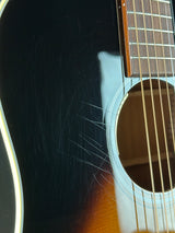 Close-up of a guitar's soundhole with visible scratches on the body.