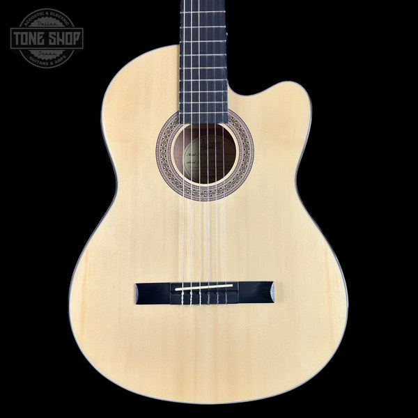 Classical guitar with a black pickguard on a black background, featuring the Tone Shop logo.
