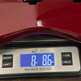 Digital scale displaying weight with a red object on top