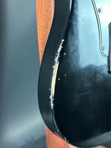 Close-up of a black shoe with a brown sole on a wooden surface