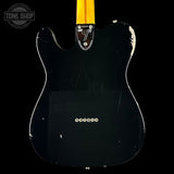 Black electric guitar with a visible brand logo on a black background