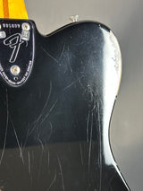 Close-up of a guitar neck with visible wear and a brand logo.