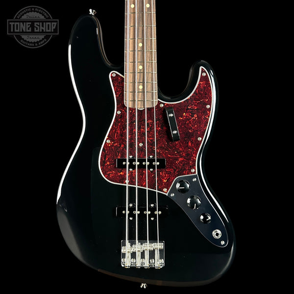 Black electric bass guitar with red flamed maple top on a black background, featuring 'Tone Shop' logo.