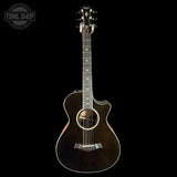 Acoustic guitar with a cutaway on a black background, featuring the Taylor brand.
