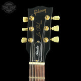 Gibson Les Paul guitar headstock with gold tuning pegs on a black background