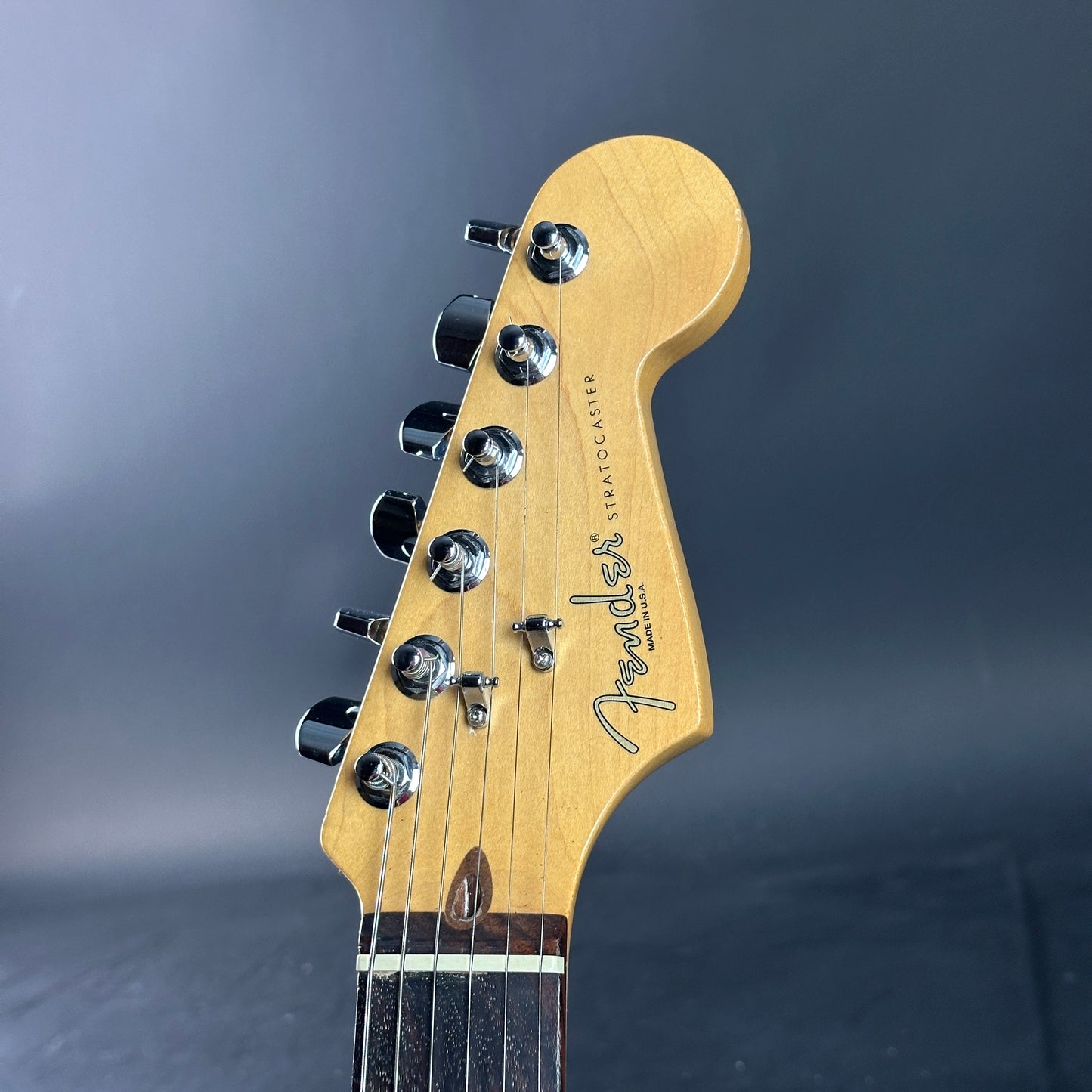 Close-up of a Fender guitar headstock on a dark background