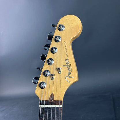 Close-up of a Fender guitar headstock on a dark background