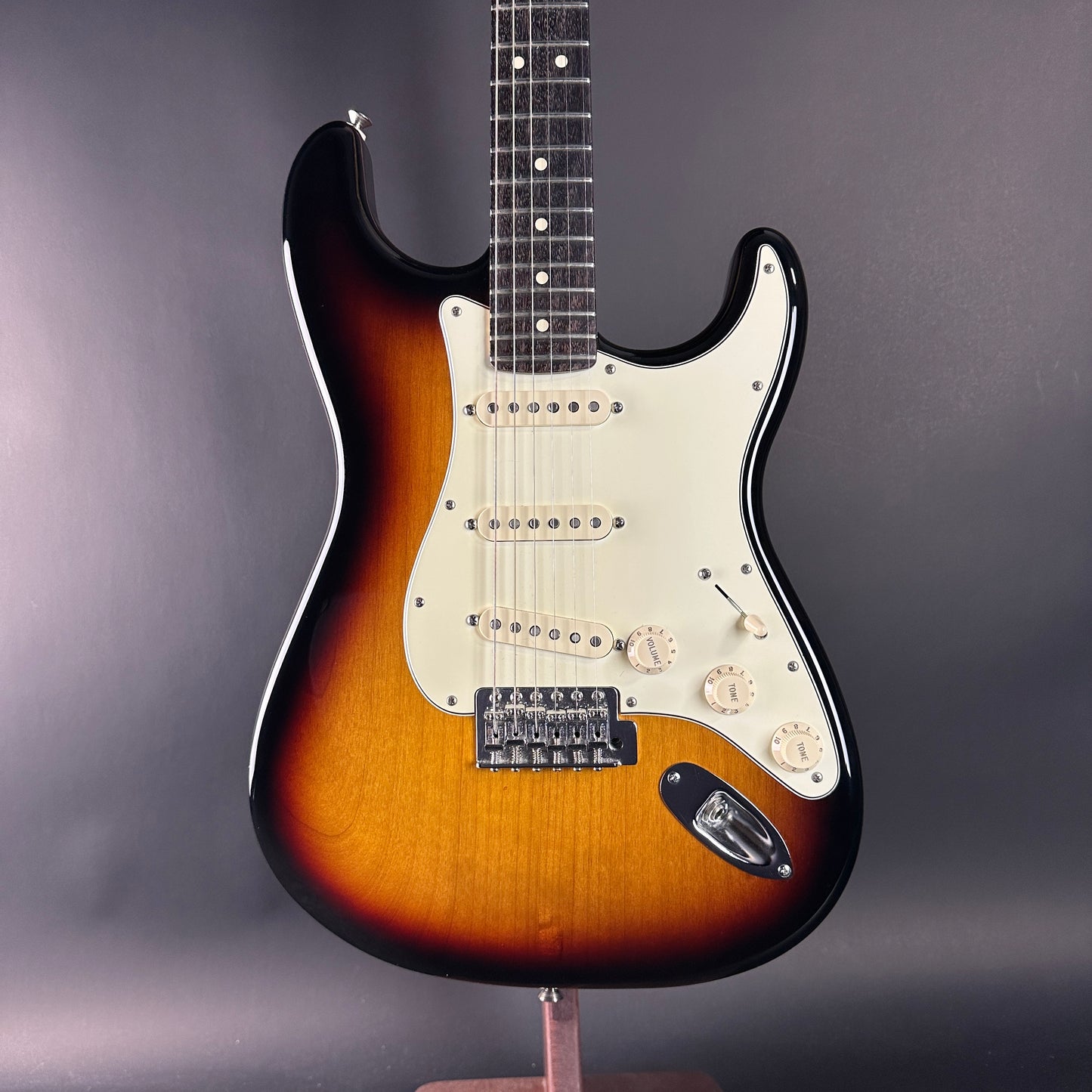 Electric guitar with a sunburst finish on a gray background