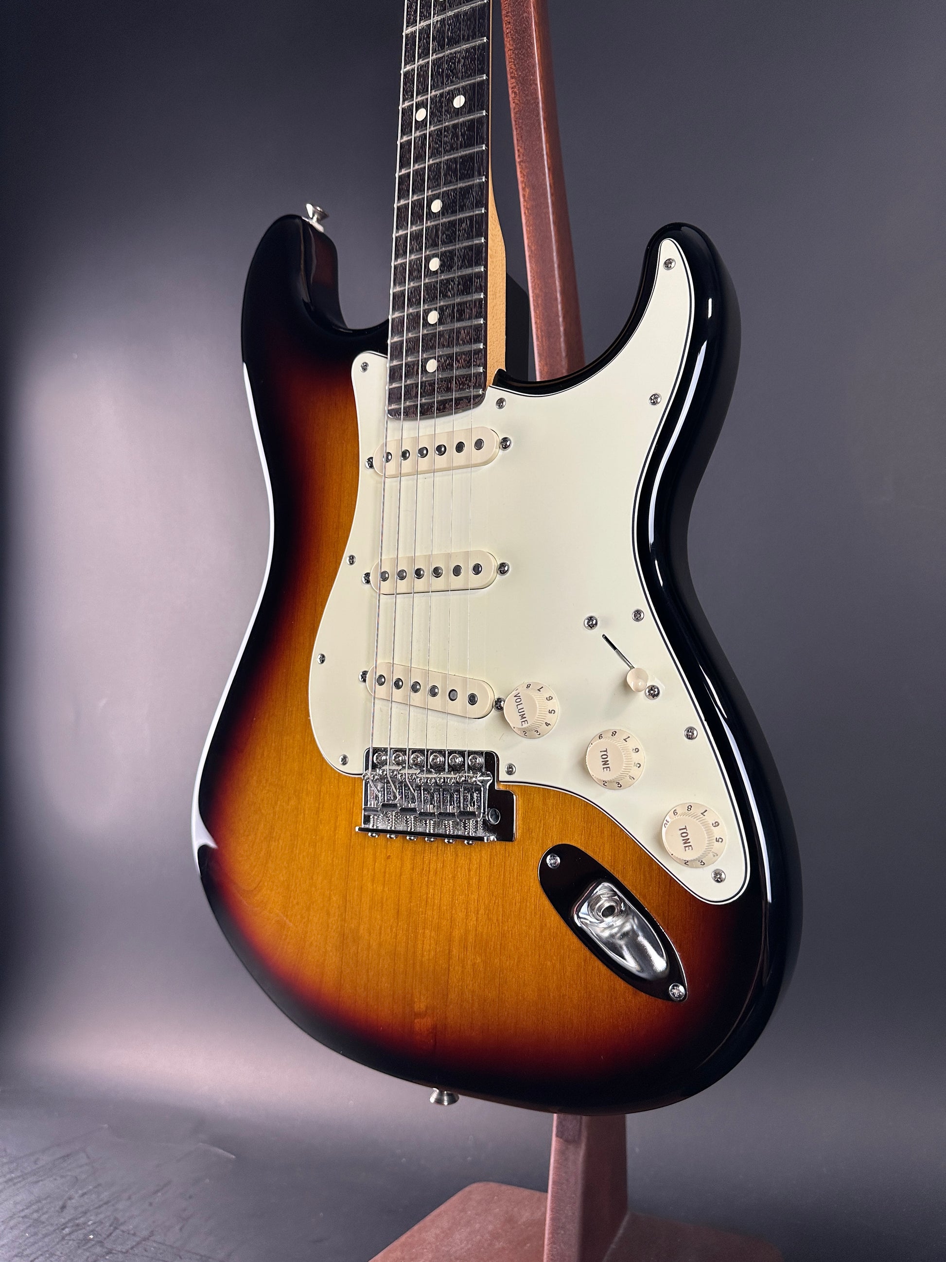 Electric guitar with sunburst finish on a gray background