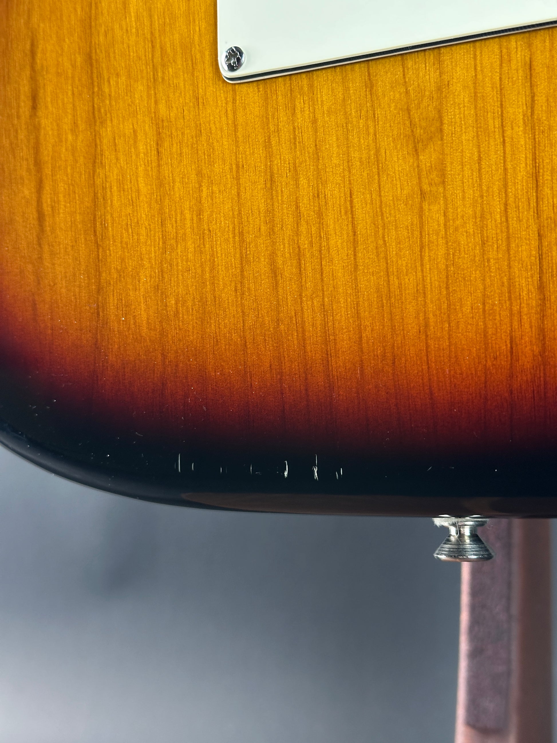 Wear on bottom edge of Used 2000 Fender American Standard Stratocaster Sunburst.