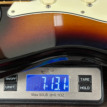 Digital scale displaying weight of a guitar, with a close-up on the scale's display.