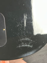 Scratched black surface with a small object on it
