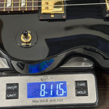 Black electric guitar on a digital scale displaying weight