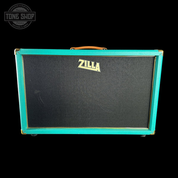 A Zilla guitar amplifier cabinet with a turquoise green frame, black speaker grille, and gold Zilla logo, shown against a black background with a Tone Shop watermark in the top left.