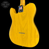 Yellow electric guitar body with a 'Tone Shop' logo in the corner.