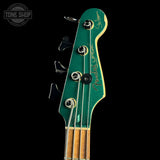 Close-up of a Fender bass guitar headstock with 'Tone Shop' logo in the corner.