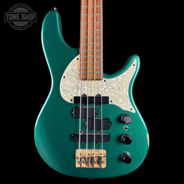 Green electric bass guitar with a white pickguard on a black background, featuring the Tone Shop logo.