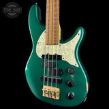 Green electric bass guitar with a visible brand logo on a black background