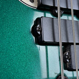Close-up of a guitar's bridge and tuning pegs on a green guitar body.