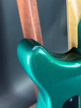 Close-up of a green electric guitar neck with a blurred background