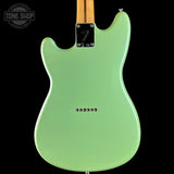 A mint green electric guitar body shown from the back against a solid black background, with a maple neck visible at the top and a Tone Shop watermark in the upper left corner.