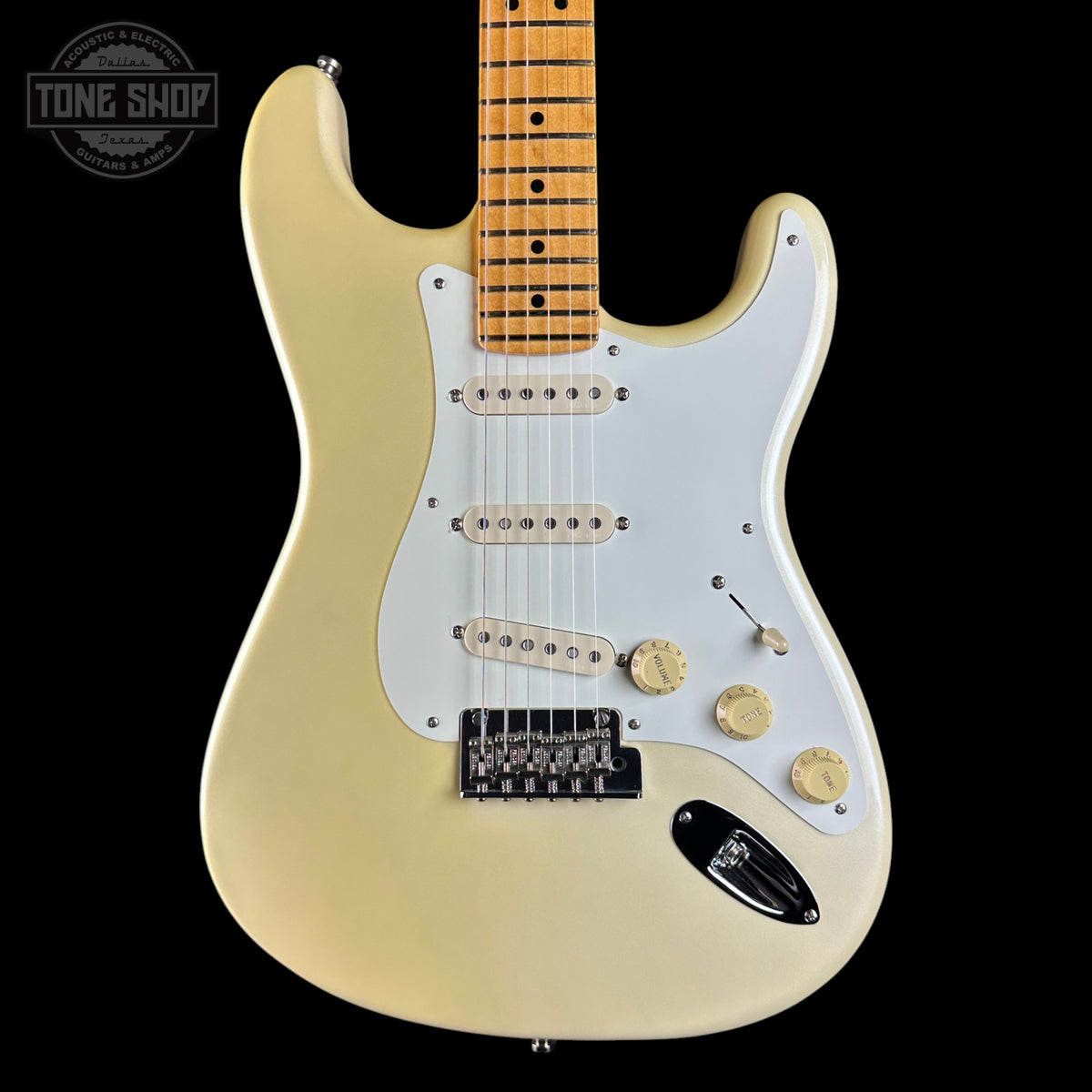 A classic Fender Stratocaster electric guitar in a cream finish, featuring a white pickguard, gold-toned hardware, and a maple neck, shown against a solid black background.