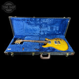 Yellow electric guitar in a blue case with 'Tone Shop' branding.