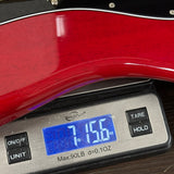 Digital scale displaying weight of a red guitar