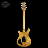 Electric guitar with a wooden finish on a black background, featuring the Tone Shop logo.
