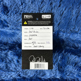 Label on a blue textured surface with text and a signature.
