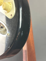 Close-up of a vintage radio with metallic and black components on a wooden surface.