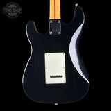 Black electric guitar with a visible brand logo on a black background