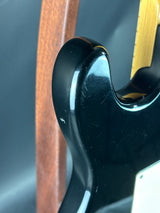 Close-up of a black door handle with a gold accent on a wooden door.