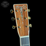 Guitar headstock with decorative inlay on a black background