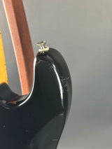 Close-up of a guitar's headstock with tuning pegs on a gray background