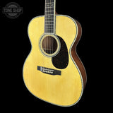 Acoustic guitar with a visible brand logo on a black background