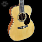 Acoustic guitar with a visible brand logo on a black background