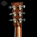 Close-up of a guitar headstock with tuning pegs on a black background, featuring the Taylor logo.