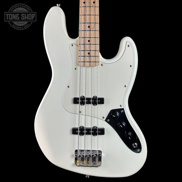 White electric bass guitar with a black pickguard on a black background, featuring the Tone Shop logo.