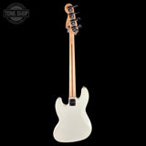 White electric bass guitar on a black background with 'Tone Shop' logo.