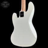 White electric guitar with a black pickguard on a black background, featuring the 'Tone Shop' logo.