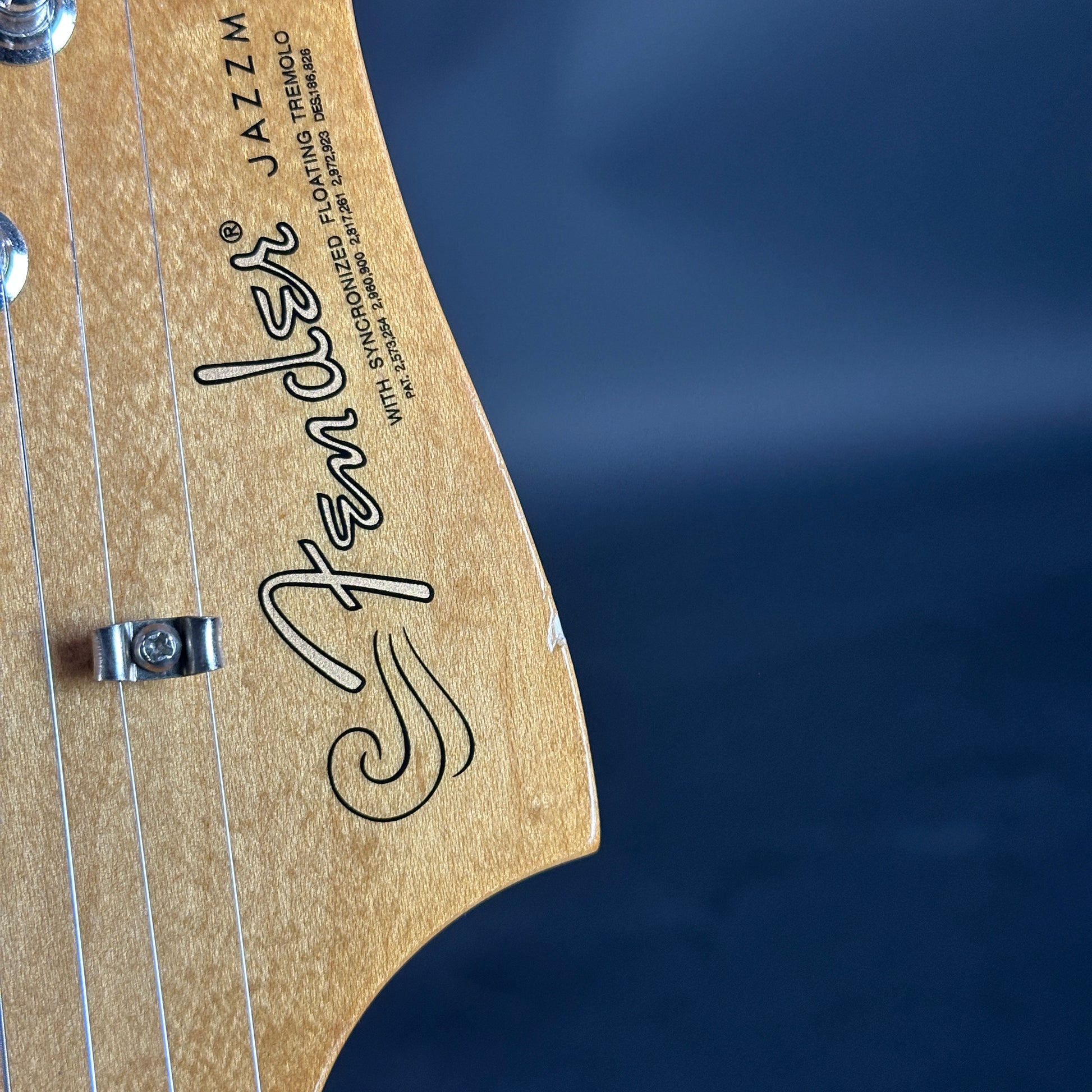 Fender logo on the back of a guitar with a dark blue background