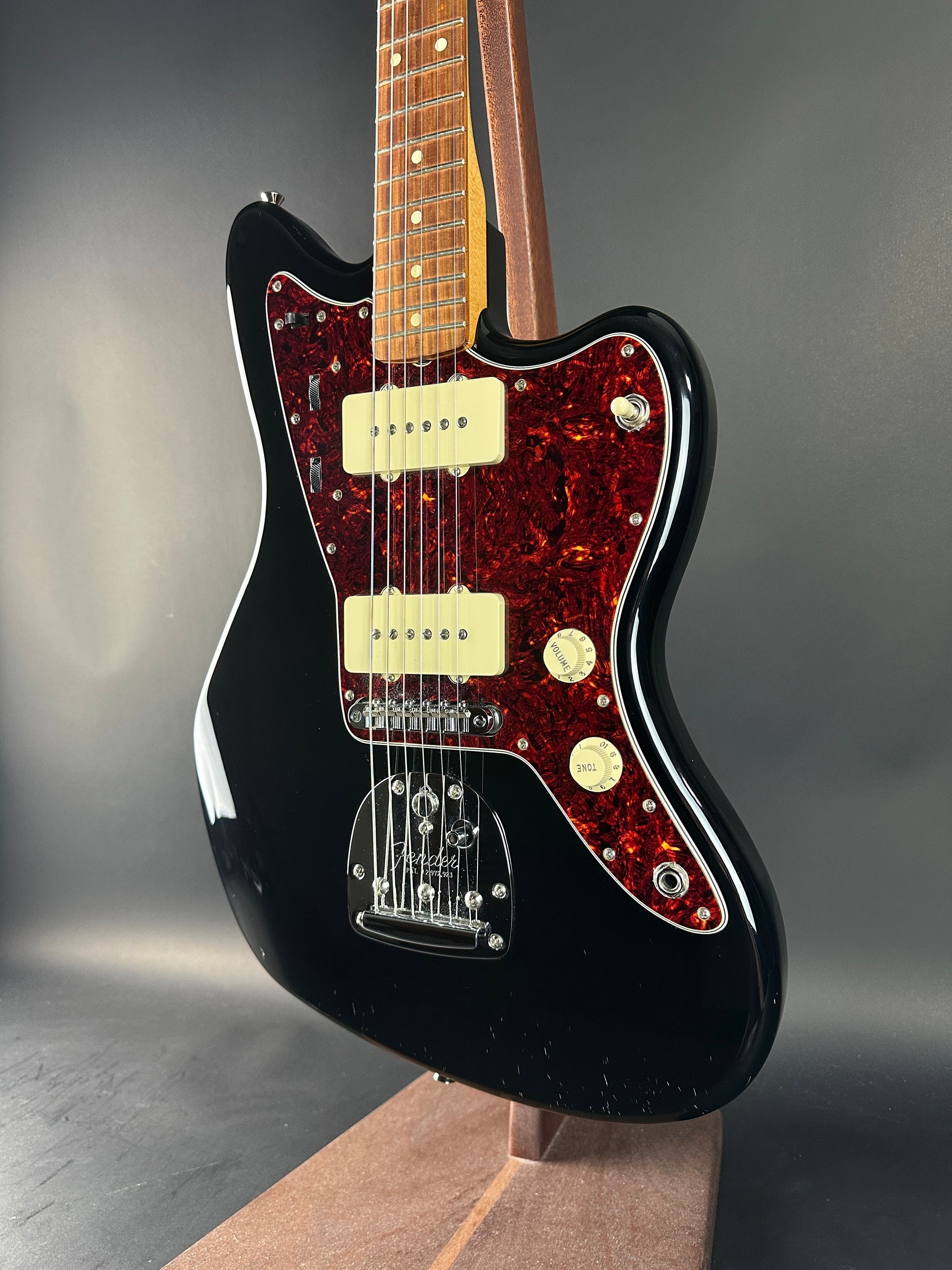 Black electric guitar with a flame maple top on a dark surface