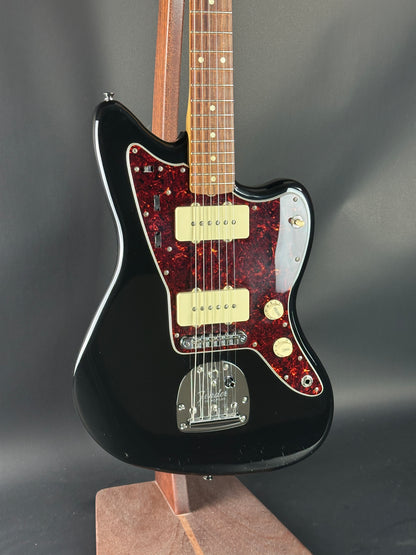 Black electric guitar with a red flame pattern on a dark background