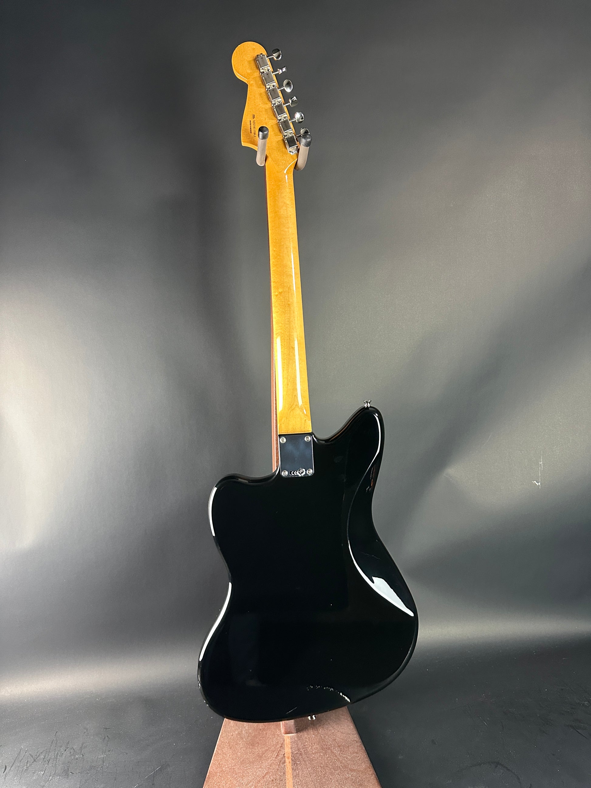 Black electric guitar on a gray background