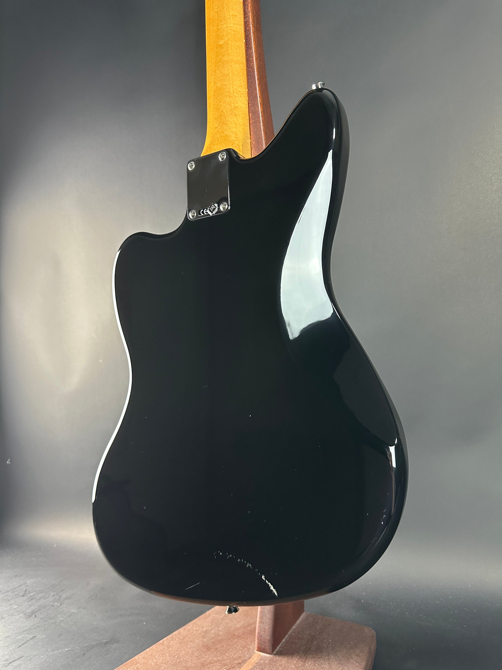 Black electric guitar body on a gray background
