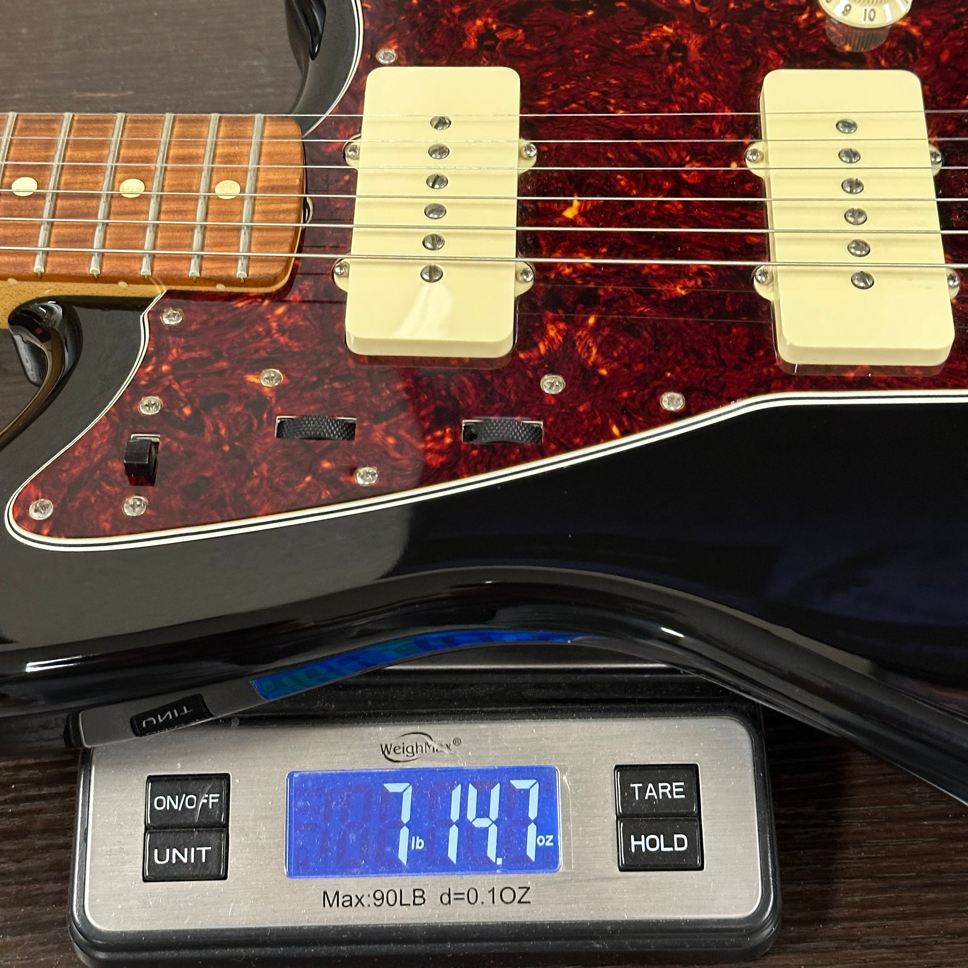 Electric guitar on a digital scale displaying weight